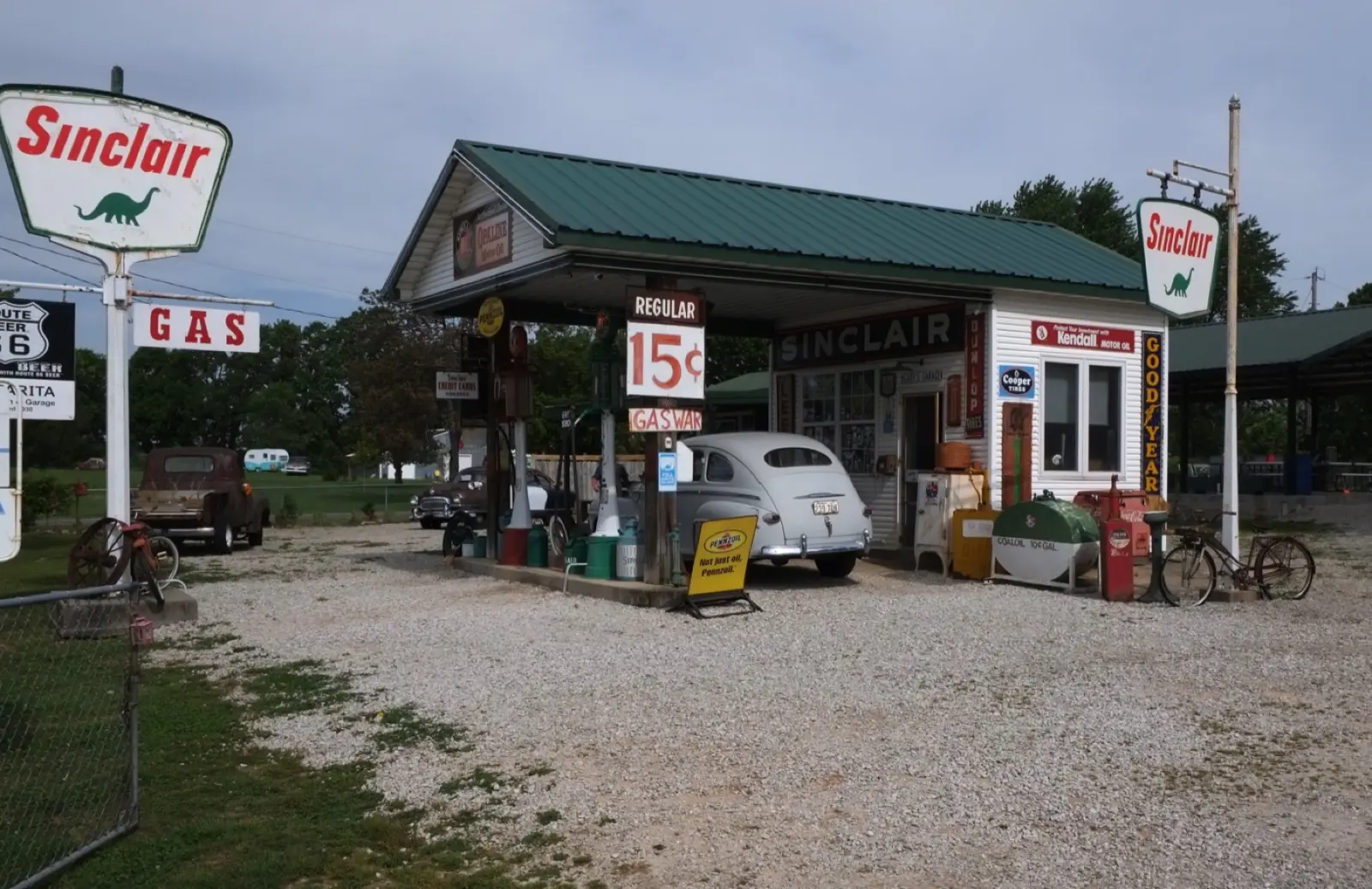 Gary's Gay Parita, a rebuilt Sinclair gas station with a green roof, vintage pumps, a 15-cent gas sign and an old car, on Route 66 at Paris Springs, Missouri