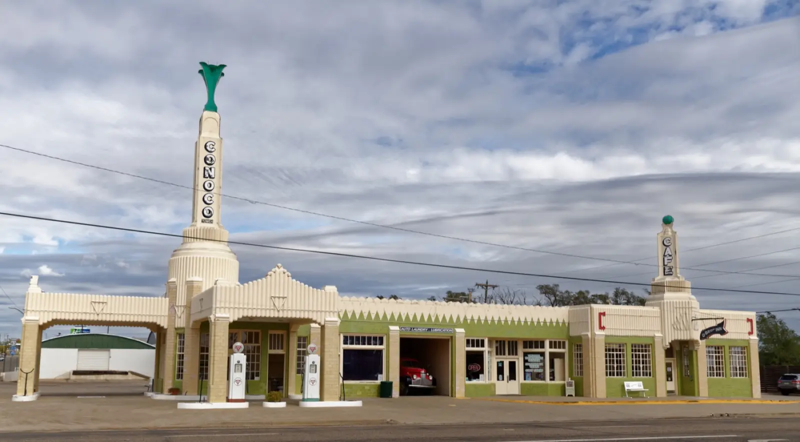 The Art Deco Tower Conoco Station and U-Drop Inn in Shamrock, Texas, with its green-topped towers and vintage pumps under a cloudy sky